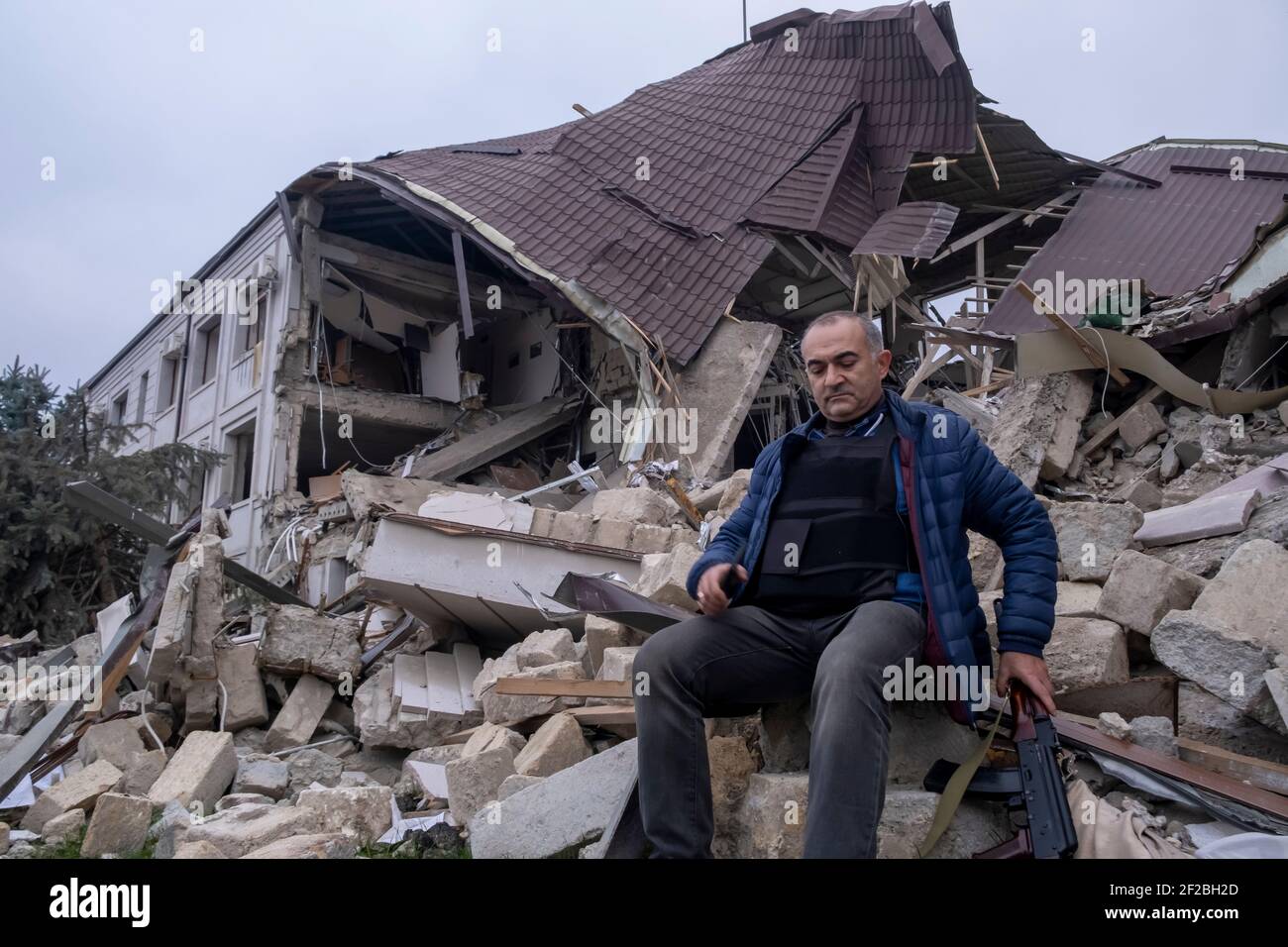 STEPANAKERT, NAGORNO KARABAKH - NOVEMBRE 04: Tevan Pogosyan consigliere del presidente armeno ed ex-membro del Parlamento armeno armato di un fucile AK-47 Kalashnikov siede nel relitto del principale edificio di controllo elettrico di Artsakh Energo distrutto da un attacco militare azero durante un conflitto militare a Stepanakert, capitale de facto dell'autoproclamata Repubblica di Artsakh o Nagorno-Karabakh, parte de jure della Repubblica di Azerbaigian il 04 novembre 2020. I combattimenti tra Armenia e Azerbaigian sul Nagorno-Karabakh conosciuto anche come la Repubblica Artsakh rieruttarono alla fine di settembre Foto Stock