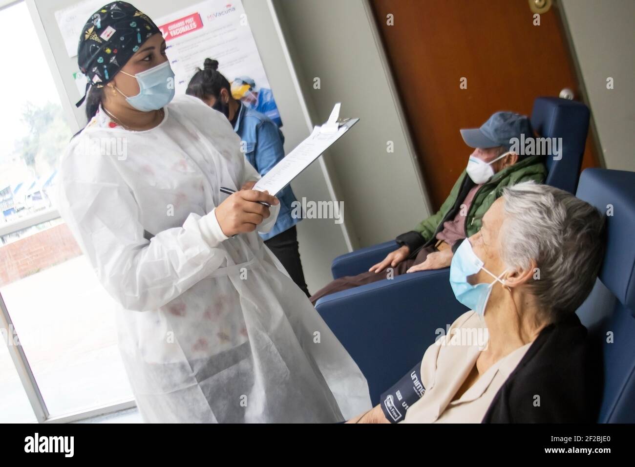 LA CALERA, COLOMBIA - MARZO 2021. Infermiere che monitora un paziente adulto anziano per essere a conoscenza di eventuali effetti avversi attribuibili al vaccino dopo l'app Foto Stock