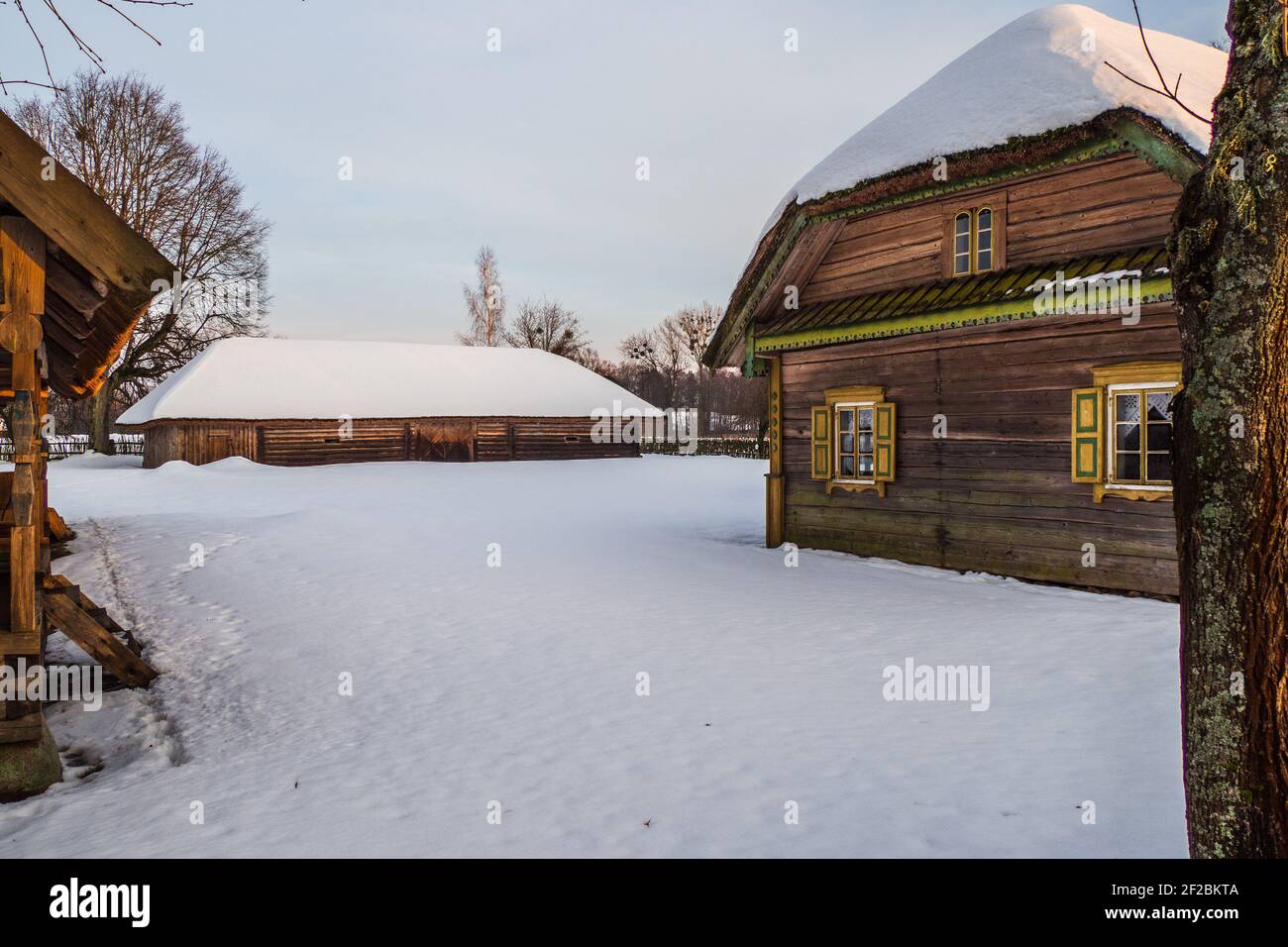 Old Village Case in legno e Sheds su una pendenza Snowy Foto Stock