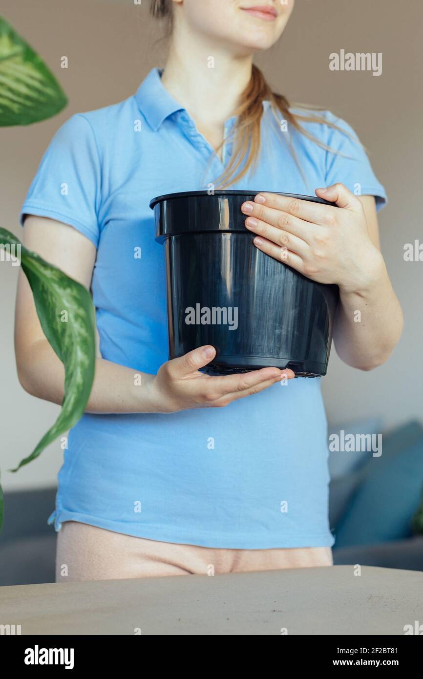 Giardiniere hobbista che tiene in mano un grande vaso nero Foto Stock