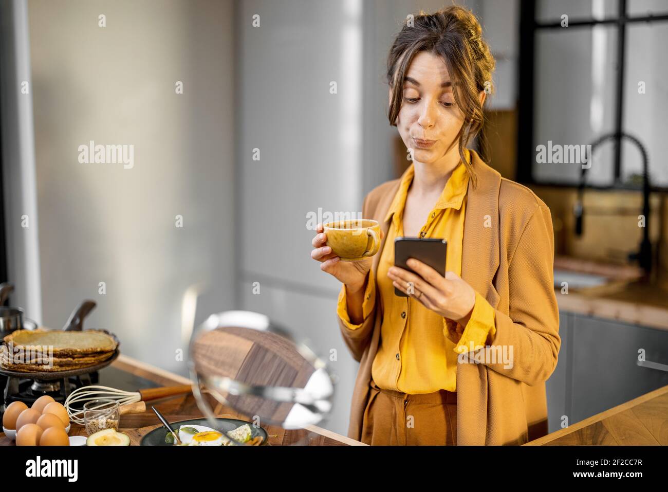 Giovane donna d'affari, troppo giovane, ha fretta di lavorare al mattino, bere caffè e usare il telefono in viaggio Foto Stock