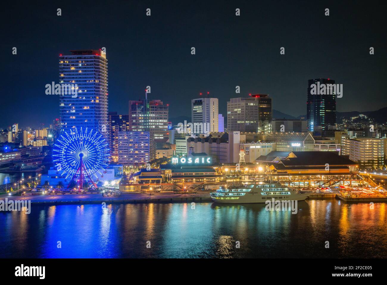 Panorama del porto cittadino di Kobe di notte. I grattacieli illuminati e la vista della distesa urbana dalla vista dal mare, Kobe, Giappone Foto Stock