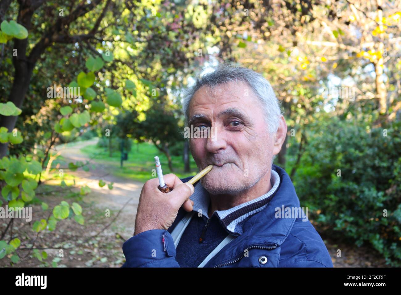 1-3-2018 Atene Grecia anziano uomo armeno che fuma un tubo dentro il parco - faccia divertente Foto Stock
