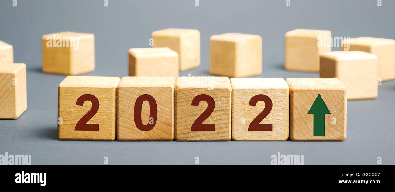 Blocchi di legno con l'iscrizione 2022 e una freccia su. Il concetto di previsione per il 2021. Previsioni aziendali. Crescita e sviluppo del business e dell'e Foto Stock