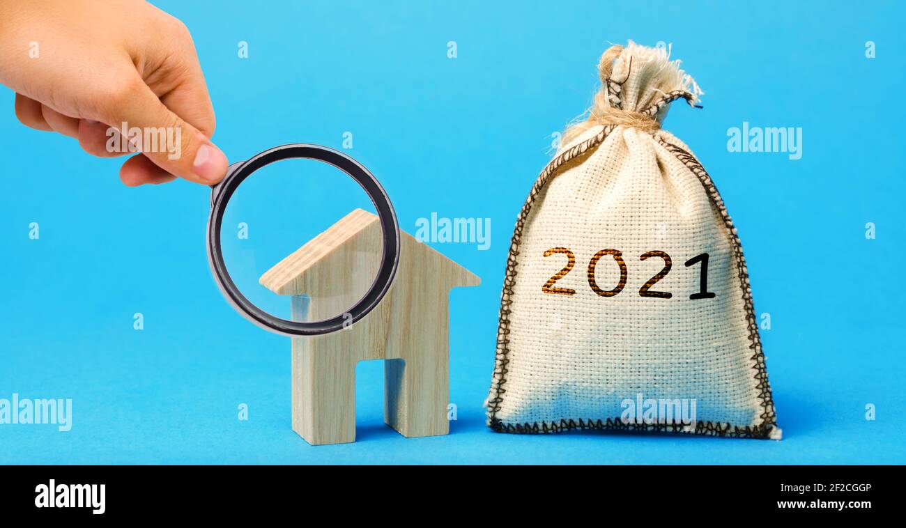 Borsa di denaro 2021 e una casa di legno. Concetto di bene immobile. Pianificazione del bilancio familiare. Investimenti, piani, risparmi. Tassi ipotecari e ipotecari. Previsioni. L Foto Stock