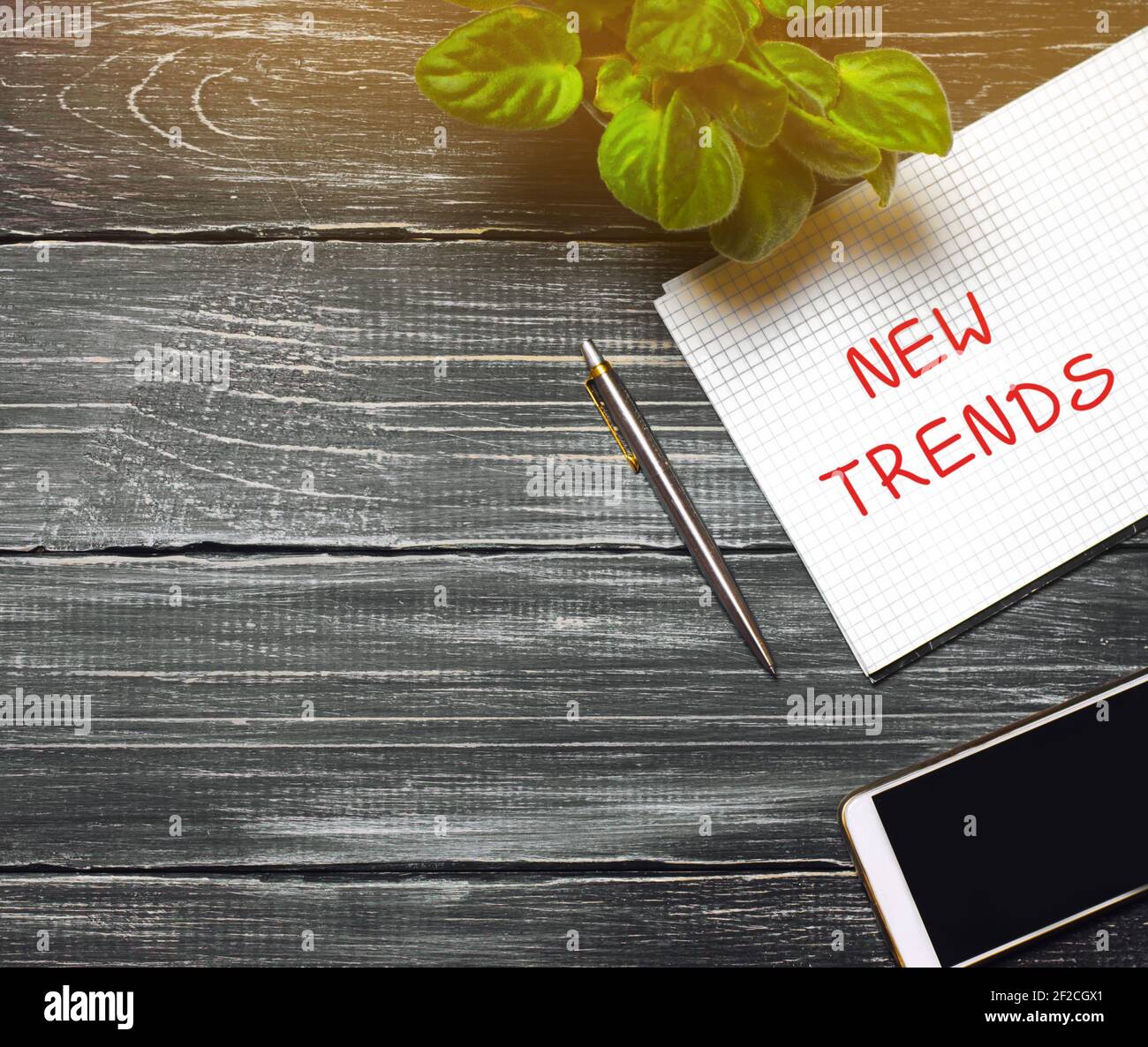 Concetto di nuove tendenze. Desktop con notebook, telefono, penna. Il concetto di ricerca di nuove tendenze e tendenze ideologiche. Tendenza esclusiva. Popolare un Foto Stock