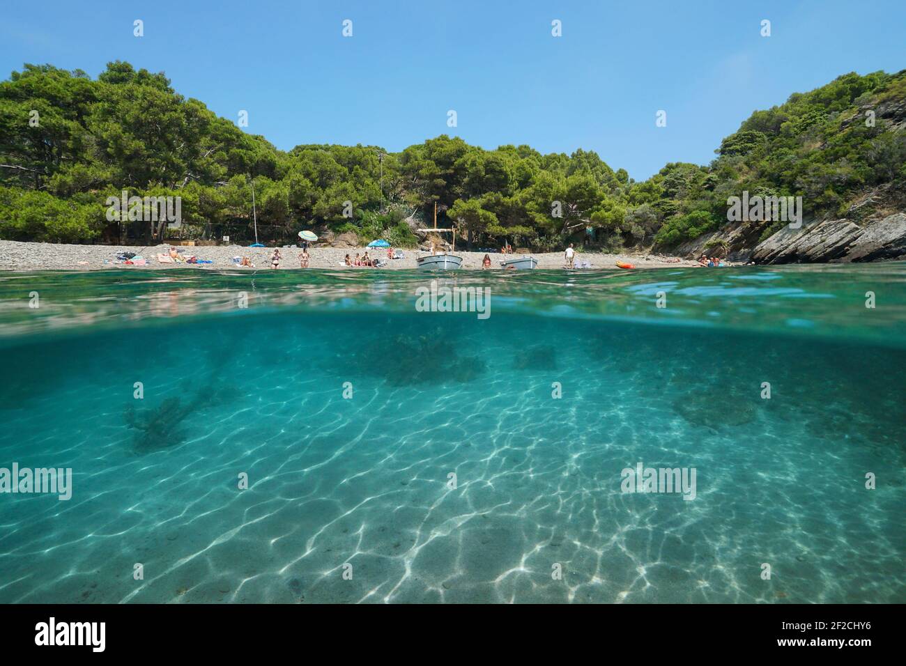 Vacanze al mare Mediterraneo in Spagna, caletta tranquilla con turisti sulla spiaggia, vista su e sotto la superficie dell'acqua, Costa Brava, Catalogna Foto Stock