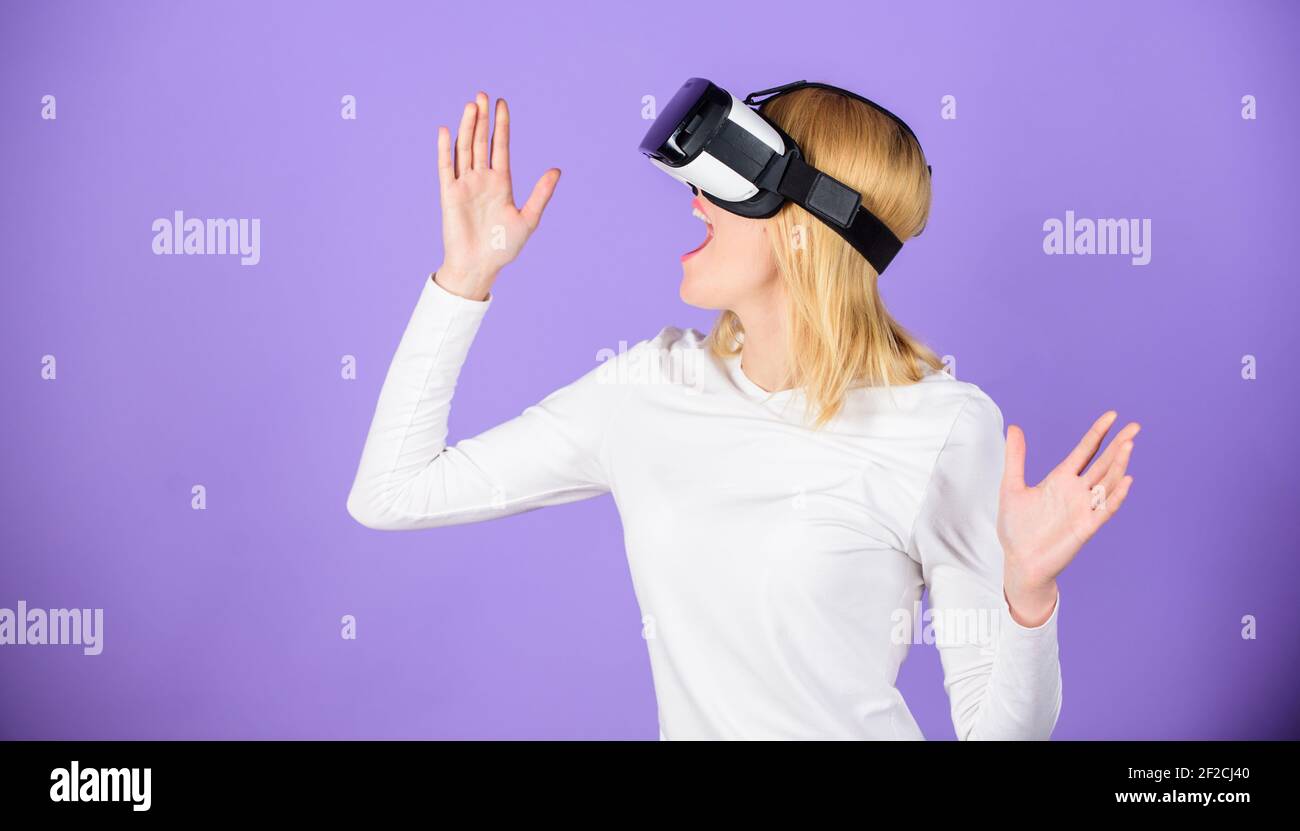La ragazza utilizza il visore vr con tecnologia moderna. Esplora la realtà virtuale. Dispositivi digitali e opportunità moderne. Donna che tiene gli occhiali del visore vr viola Foto Stock