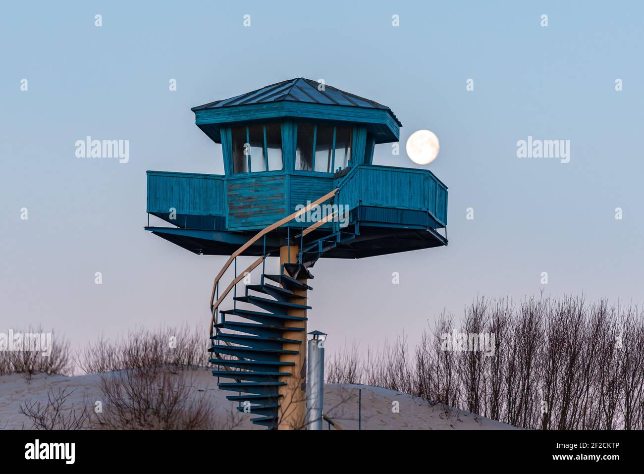 luna piena al mattino e una torre per la spiaggia salvatori in blu con scale e cespugli di sabbia Foto Stock