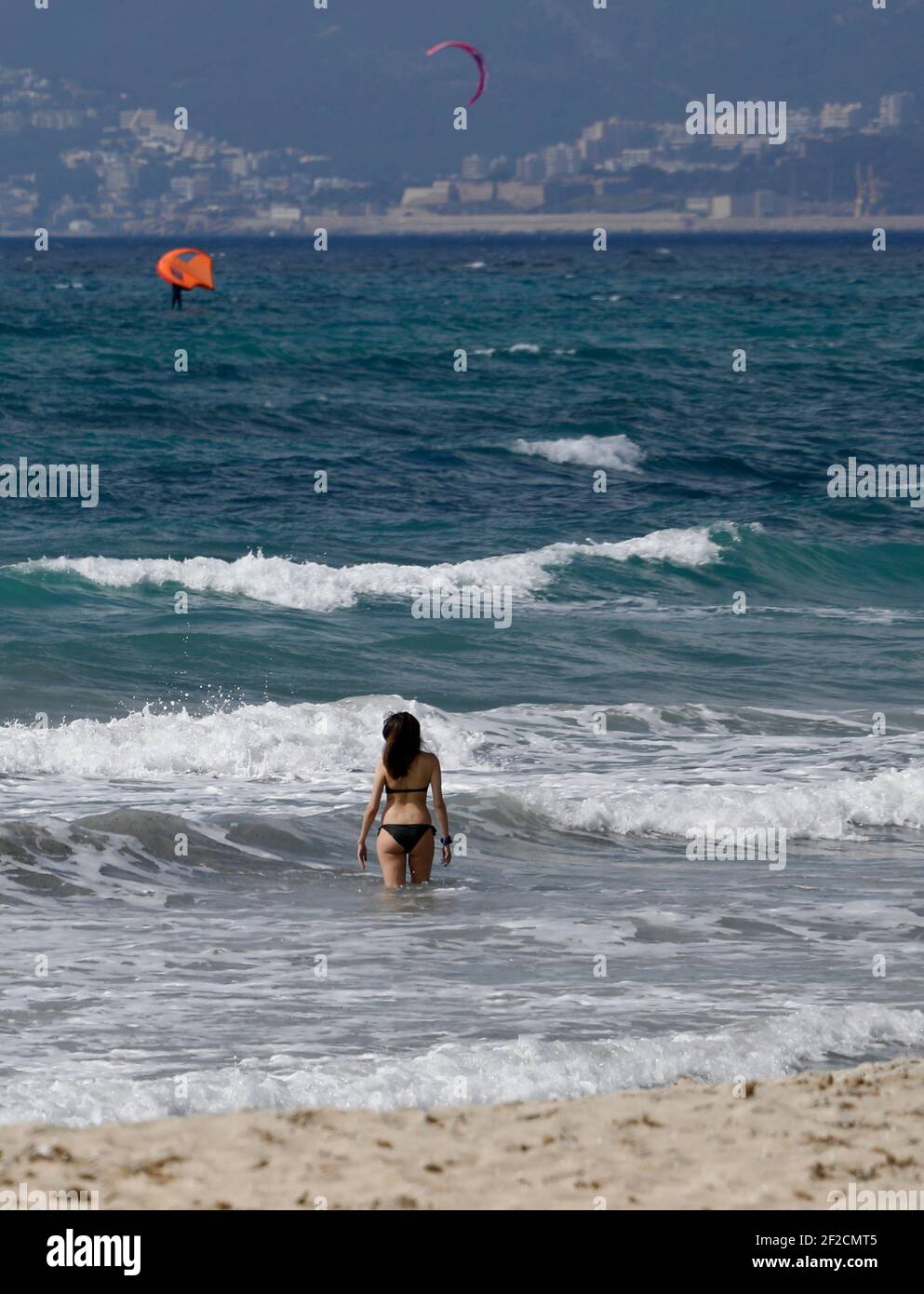 Palma, Spagna. 11 Marzo 2021. Una donna va per una nuotata nelle onde alla spiaggia di Arenal. I tour operator tedeschi sperano di riportare i turisti a Maiorca dalle vacanze di Pasqua. Credit: Clara Margais/dpa - ATTENZIONE: I nomi dei tubi sono stati pixelati per motivi legali/dpa/Alamy Live News Foto Stock