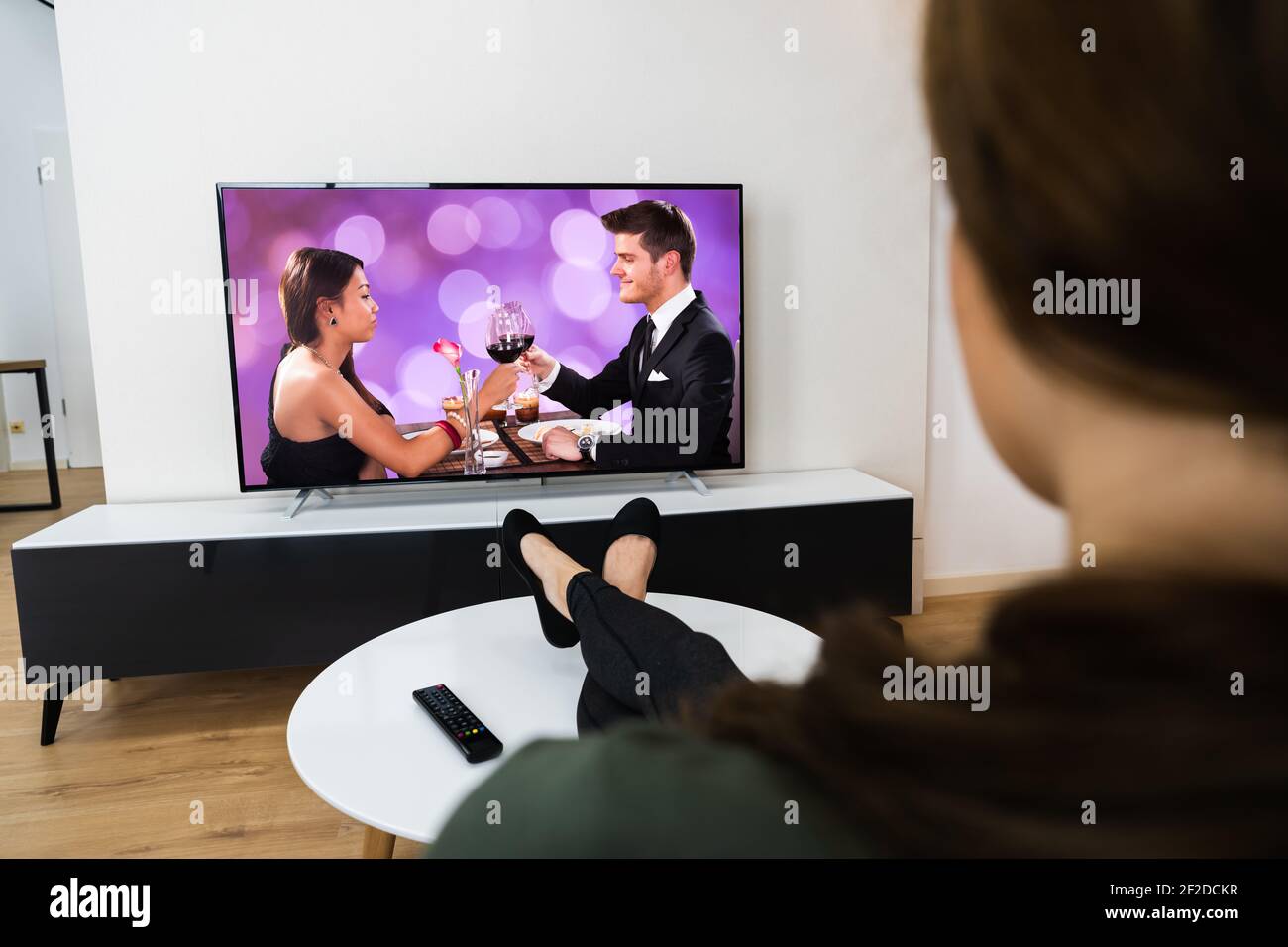 Donna che guarda un film TV su Smart Television nel soggiorno Foto Stock