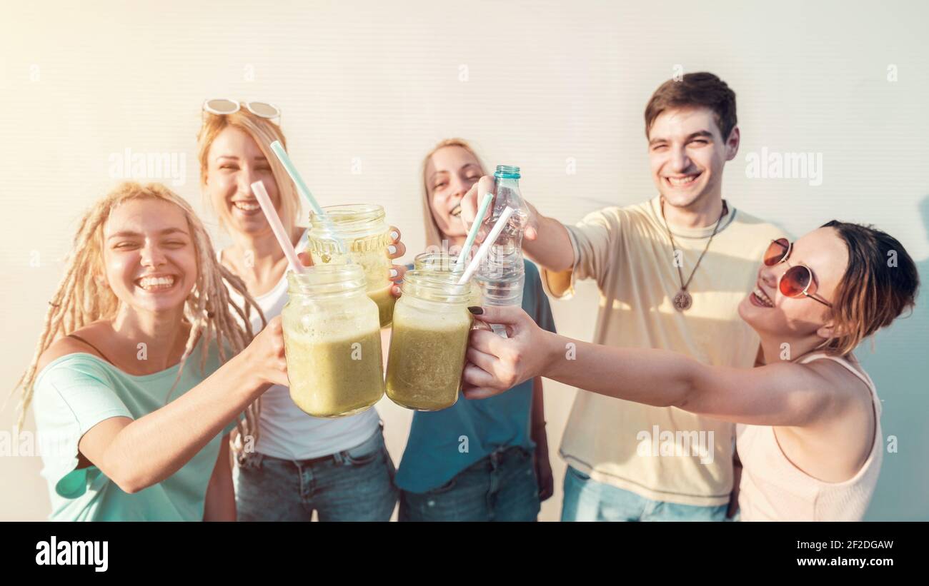 Gruppo di giovani amici celebrativo toast con fresche bevande biologiche frullati, bevande salutari e concetto estivo Foto Stock