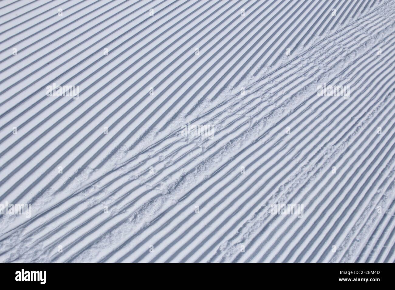 Linee parallele nella neve appena curata in una stazione sciistica Foto Stock