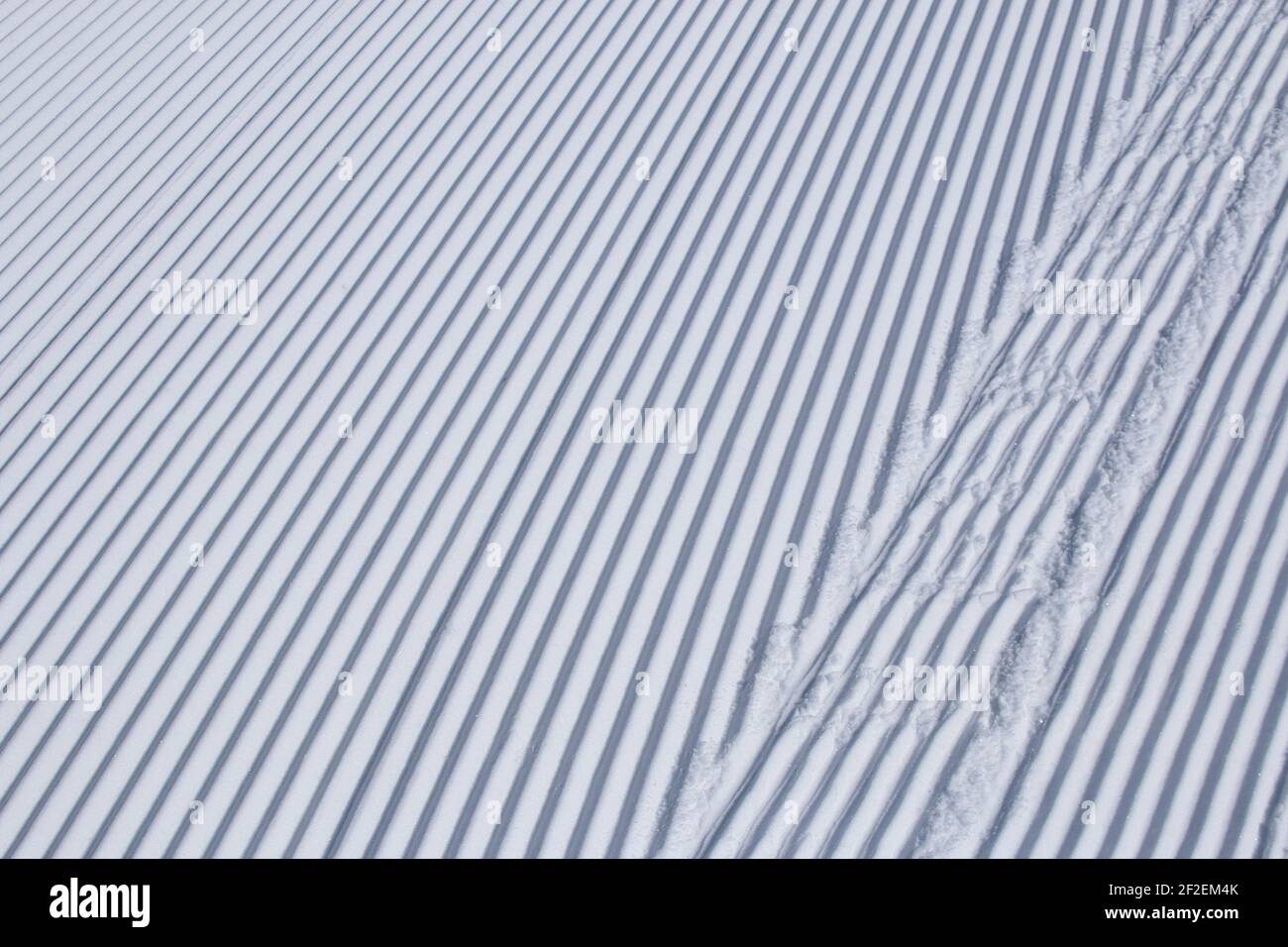 Linee parallele nella neve appena curata in una stazione sciistica Foto Stock