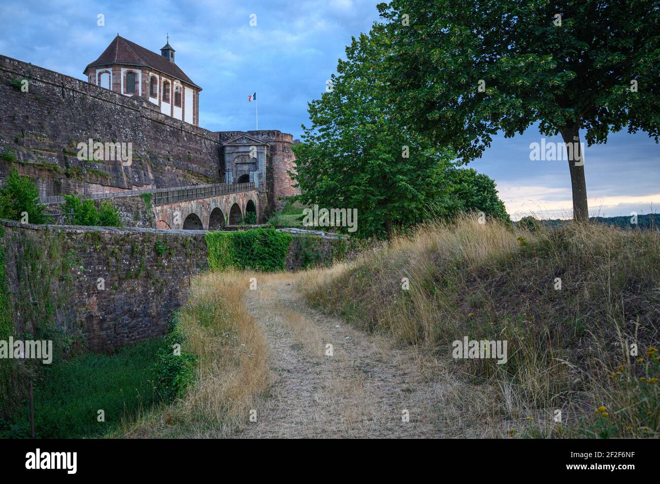 Percorso che conduce alla fortezza storica su collina. Mura alte e forti a difesa Cittadella di Bitche, Mosella, Francia. Foto Stock