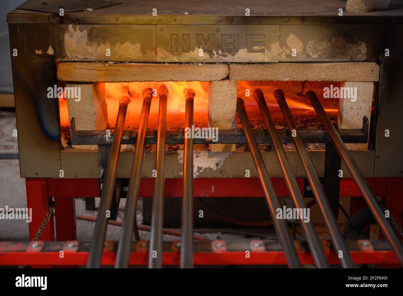 Fusione del vetro in forno ad alta temperatura. Soffianti in vetro in attesa di lavoratori. Primo piano degli interni di vetreria. Foto Stock