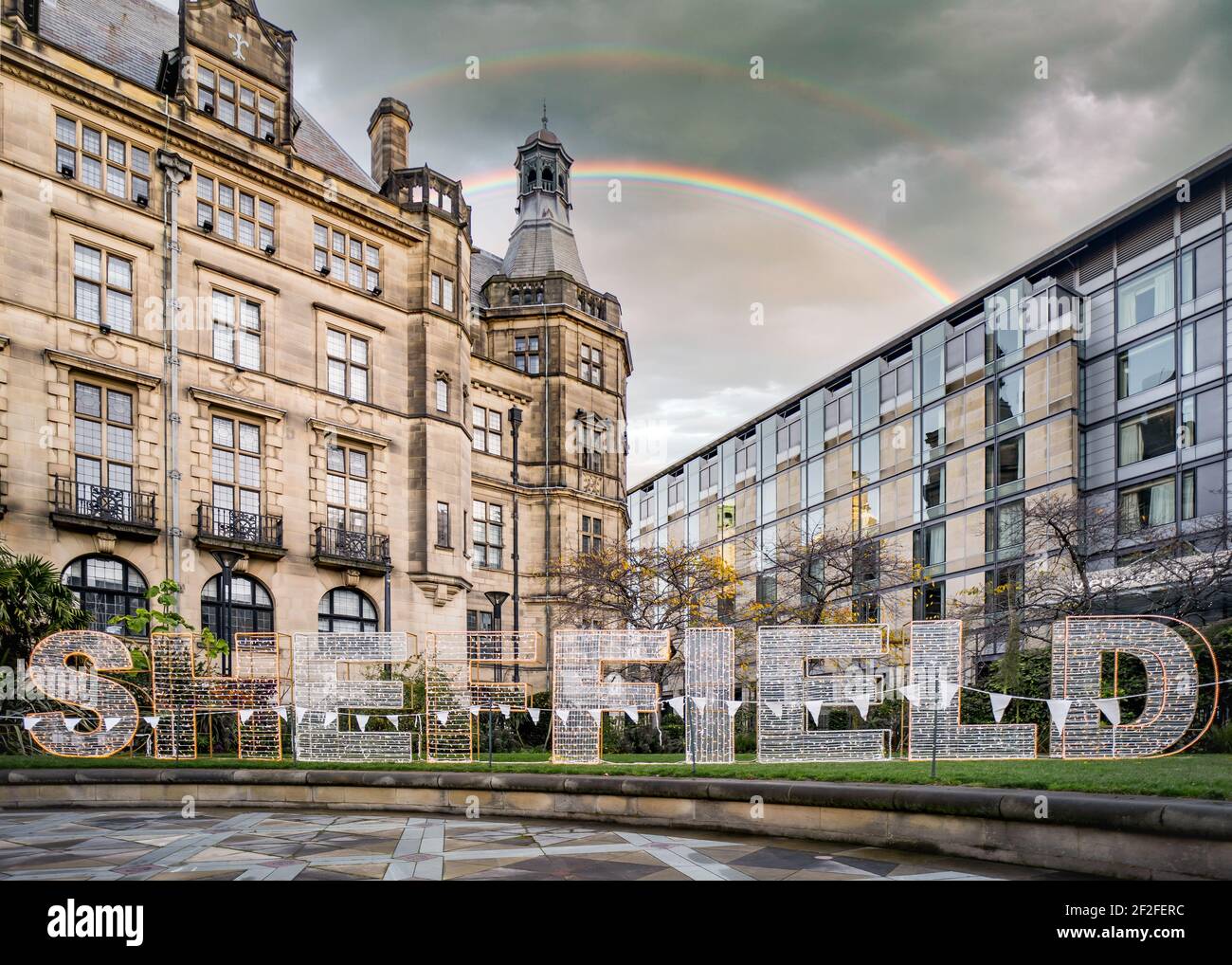 Sheffield Letteratura di testo in acciaio nel centro della città del South Yorkshire fuori comune municipio con doppio arcobaleno in cielo nuovo vecchi edifici senza persone Foto Stock
