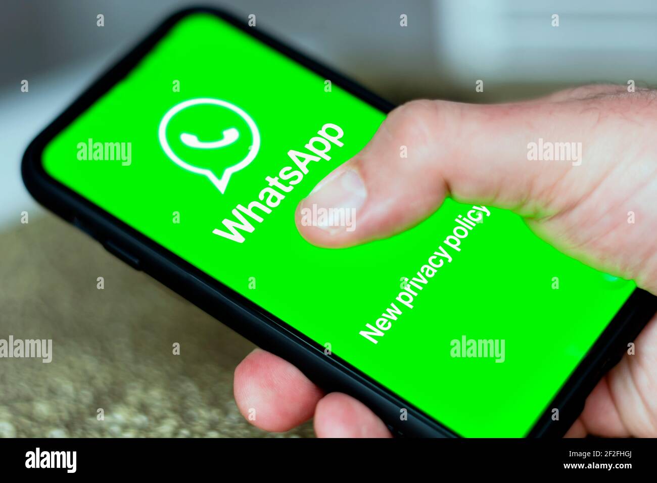Roma, Italia, febbraio 2021: Un uomo che scrive sullo schermo del suo cellulare per verificare la nuova informativa sulla privacy di Whatsapp Foto Stock