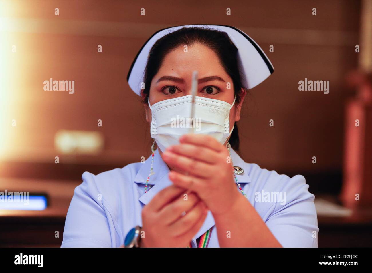 Bangkok, Thailandia. 12 marzo 2021. Un operatore sanitario detiene una siringa medica del vaccino AstraZeneneca presso l'Istituto per le malattie infettive Bambrasnaradura nella provincia di Nonthaburi, alla periferia di Bangkok. Il primo ministro tailandese Prayuth Chan o-Cha e i suoi ministri del governo hanno rinviato bruscamente le loro vaccinazioni di Covid-19 previste per venerdì, dopo che diversi paesi europei hanno sospeso l'uso del vaccino di AstraZeneca su rapporti che alcuni pazienti avevano sviluppato coaguli di sangue. Credit: SOPA Images Limited/Alamy Live News Foto Stock