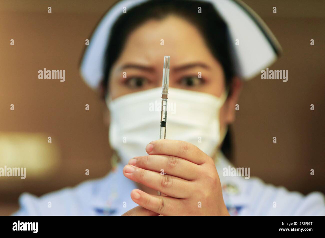 Bangkok, Thailandia. 12 marzo 2021. Un operatore sanitario detiene una siringa medica del vaccino AstraZeneneca presso l'Istituto per le malattie infettive Bambrasnaradura nella provincia di Nonthaburi, alla periferia di Bangkok. Il primo ministro tailandese Prayuth Chan o-Cha e i suoi ministri del governo hanno rinviato bruscamente le loro vaccinazioni di Covid-19 previste per venerdì, dopo che diversi paesi europei hanno sospeso l'uso del vaccino di AstraZeneca su rapporti che alcuni pazienti avevano sviluppato coaguli di sangue. Credit: SOPA Images Limited/Alamy Live News Foto Stock