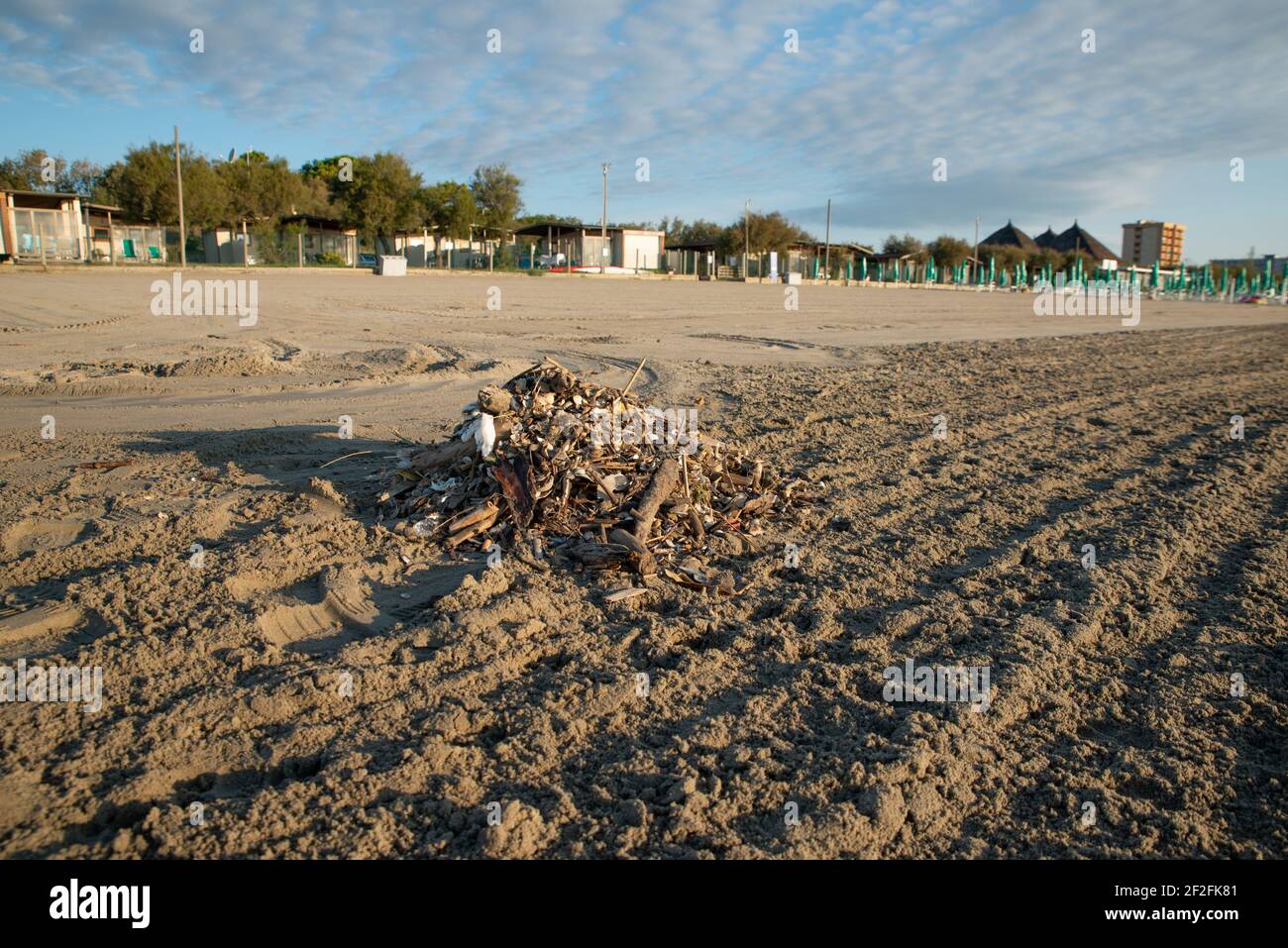 Un piccolo mucchio di rifiuti vicino alla spiaggia di sabbia pulita vicino al Lido Degli Scacchi di Comacchio Foto Stock