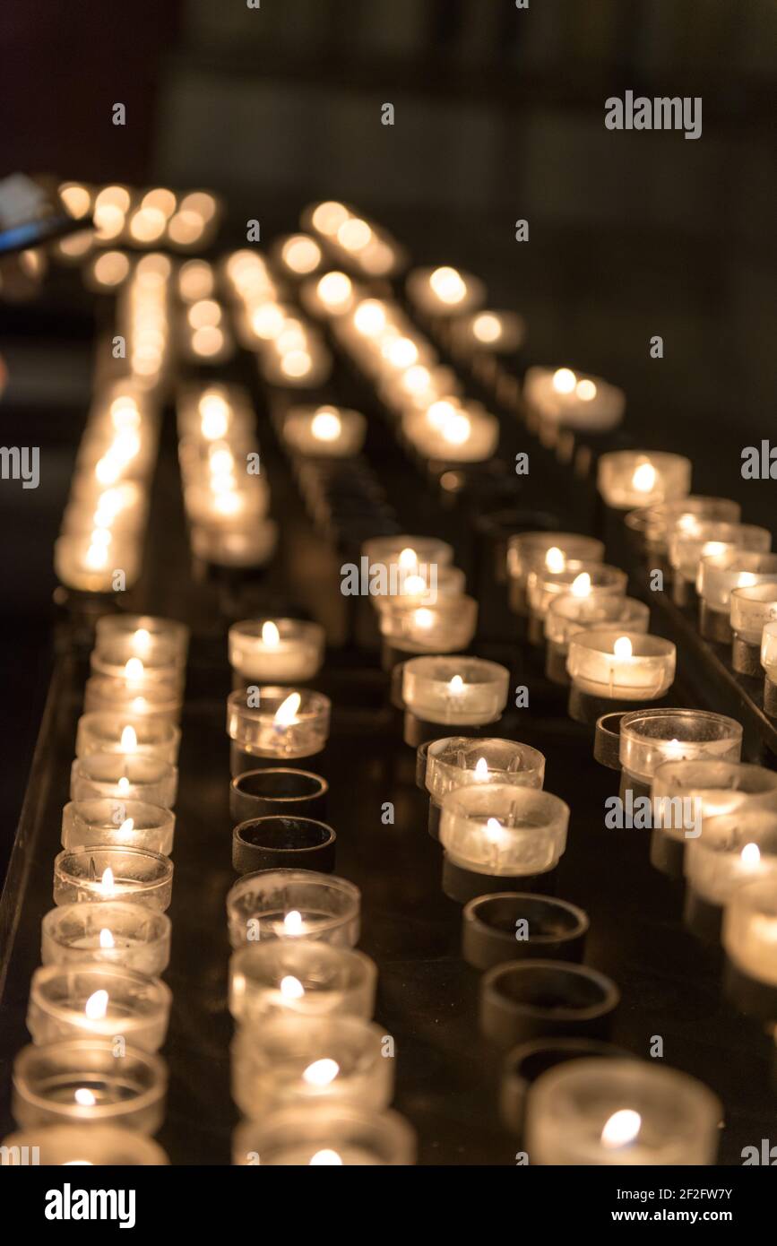bruciare candele sacrificali in una chiesa Foto Stock
