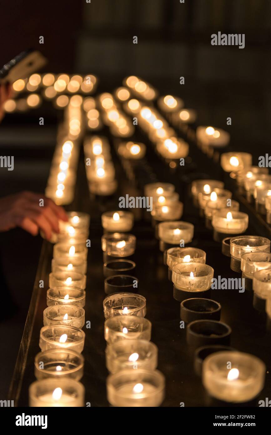 bruciare candele sacrificali in una chiesa Foto Stock