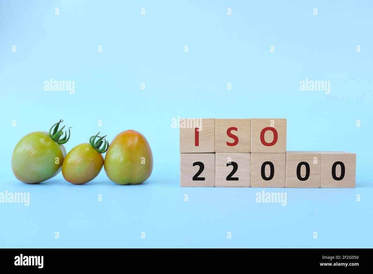 ISO 22000 o sistema di gestione della sicurezza alimentare su blocchi di legno su sfondo blu. Foto Stock