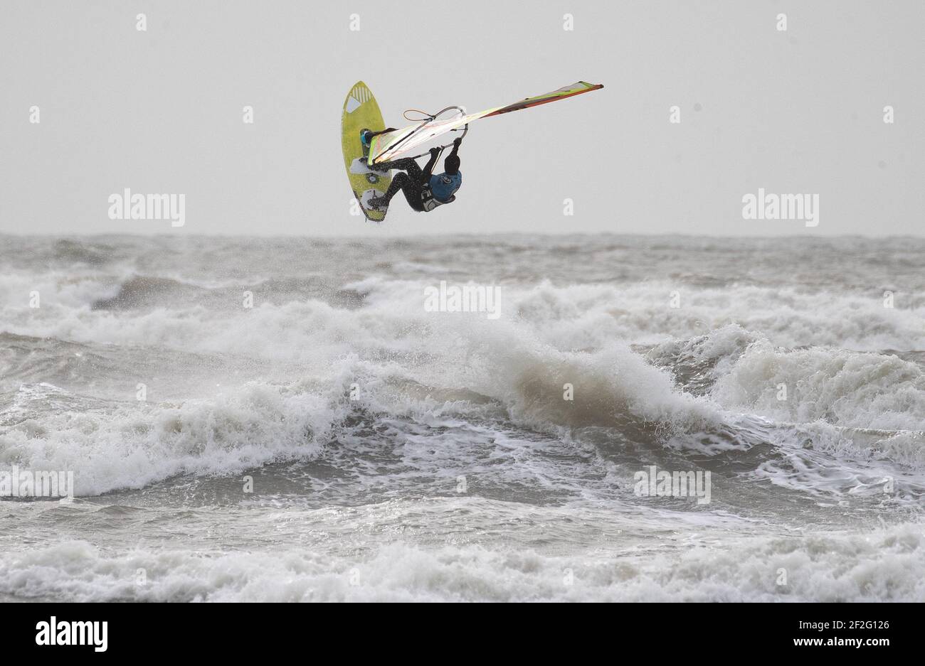 Un windsurfer surfs nel mare ruvido al largo di West Wittering spiaggia in West Sussex. Data immagine: Venerdì 12 marzo 2021. Foto Stock