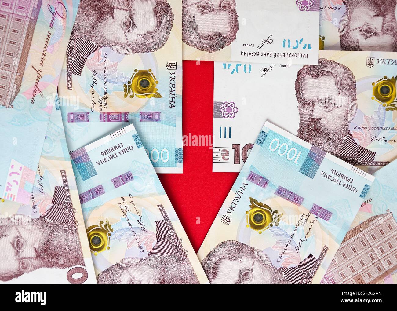 Una freccia fiancheggiata da banconote di hryvnias ucraino ed euro 2 Foto Stock