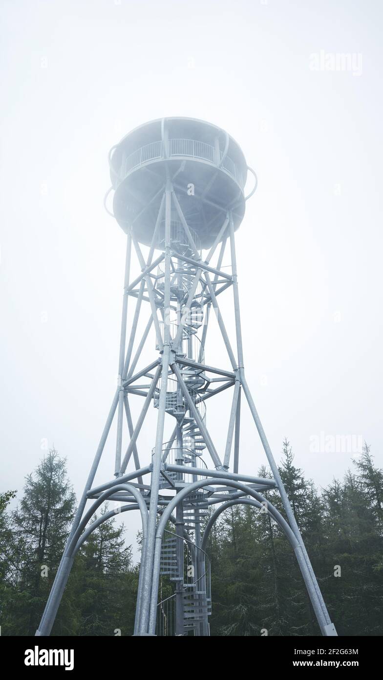 Torre di osservazione della montagna nella foresta in una giornata di nebbia. Foto Stock