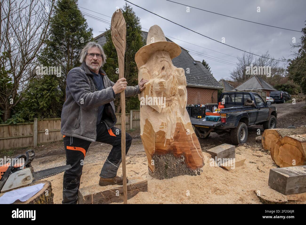 Jona Cleaver intagliando una scultura in legno di dimensioni giganti di Gandalf dal Signore degli anelli su un albero d'acero per una commissione privata, Hampshire, Inghilterra Foto Stock