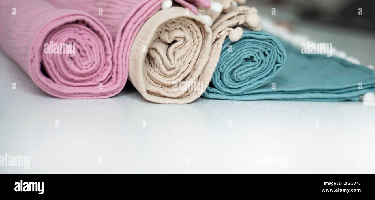 Rotoli di asciugamani multicolore in delicati colori pastello. Tessuti per la casa in cotone biologico. Bordo tessile. Spazio di copia per il testo. Foto Stock