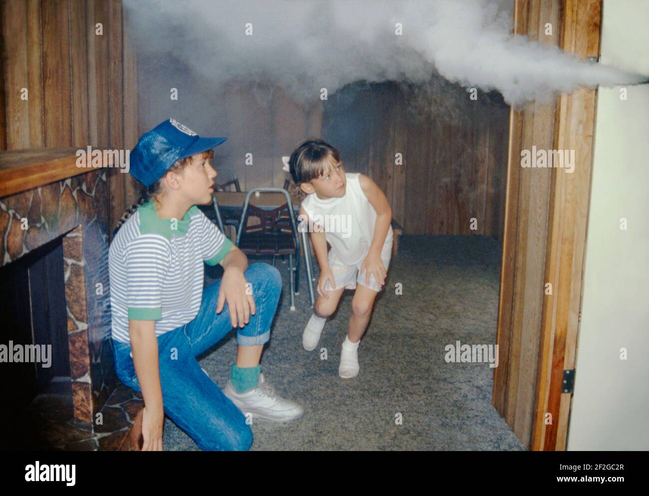 Due ragazze sono all'interno di un rimorchio che li istruisce sulla sicurezza antincendio nella contea di Manatee, Florida, Stati Uniti in 1990. Qui, in un mock-up domestico, una dimostrazione li avvicina per sperimentare i rischi del fumo in un fuoco domestico. La mostra mobile, sponsorizzata dal Consiglio di sicurezza locale), potrebbe essere guidata a scuole ed eventi pubblici in tutta la contea. Questa immagine proviene da una vecchia trasparenza di colore amatoriale americana. Foto Stock