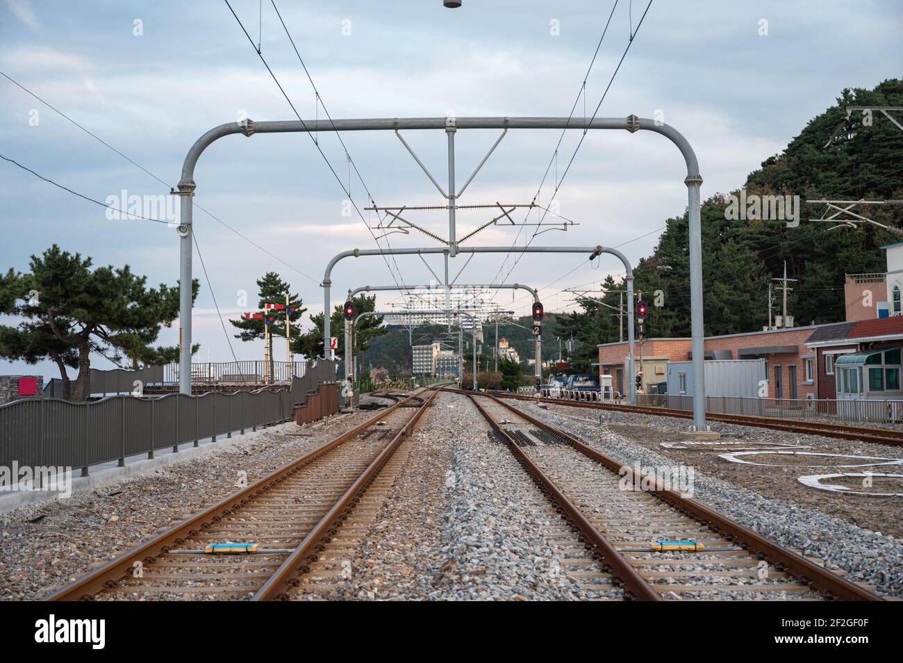 Binario ferroviario e polo elettrico per pendolari alla stazione Foto Stock