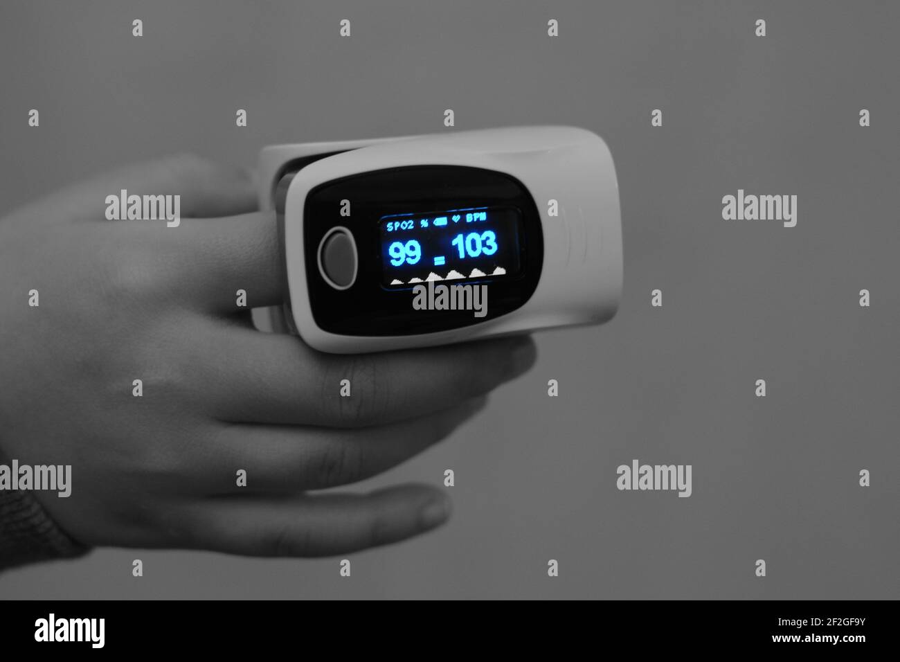 pulsossimetro fingertip collegato al dito indice di un bambino che misura la saturazione di ossigeno nel sangue e la frequenza cardiaca Foto Stock