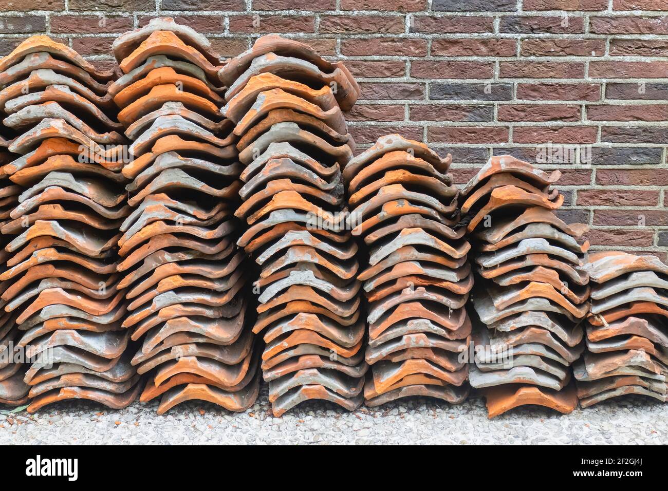 Vecchie tegole impilate usate per la ristrutturazione su un olandese cantiere Foto Stock
