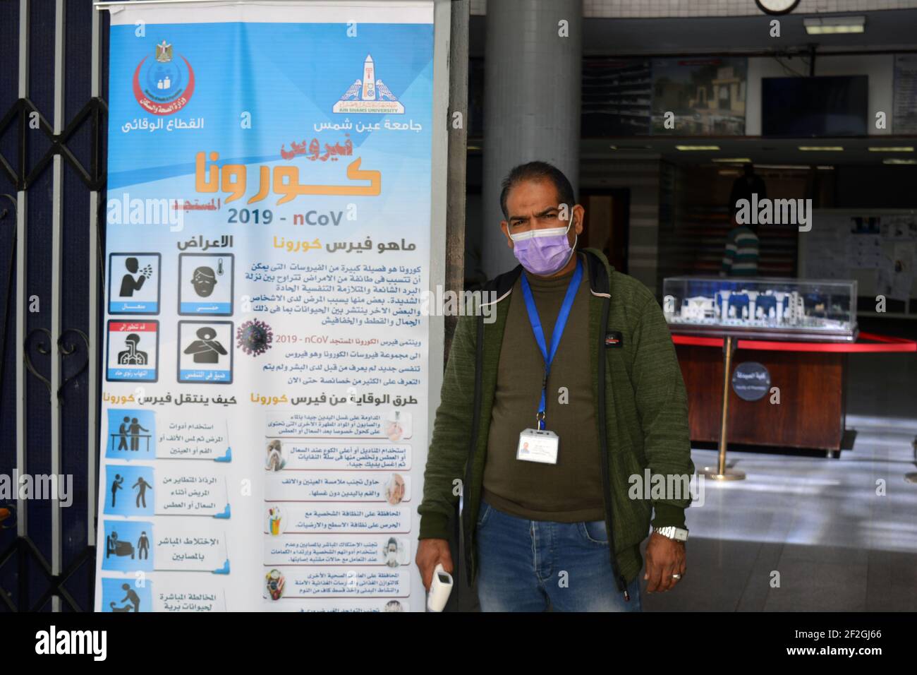 Cairo, Egitto - 11 marzo 2020. Banner di sensibilizzazione sul coronavirus covid19 pandemia e una persona è pronta a prendere la temperatura dei visitatori prima dell'ingresso Foto Stock