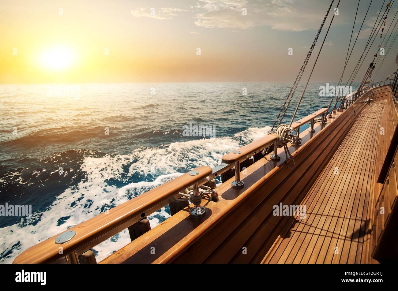 Barca a vela in mare rosso al tramonto Foto Stock