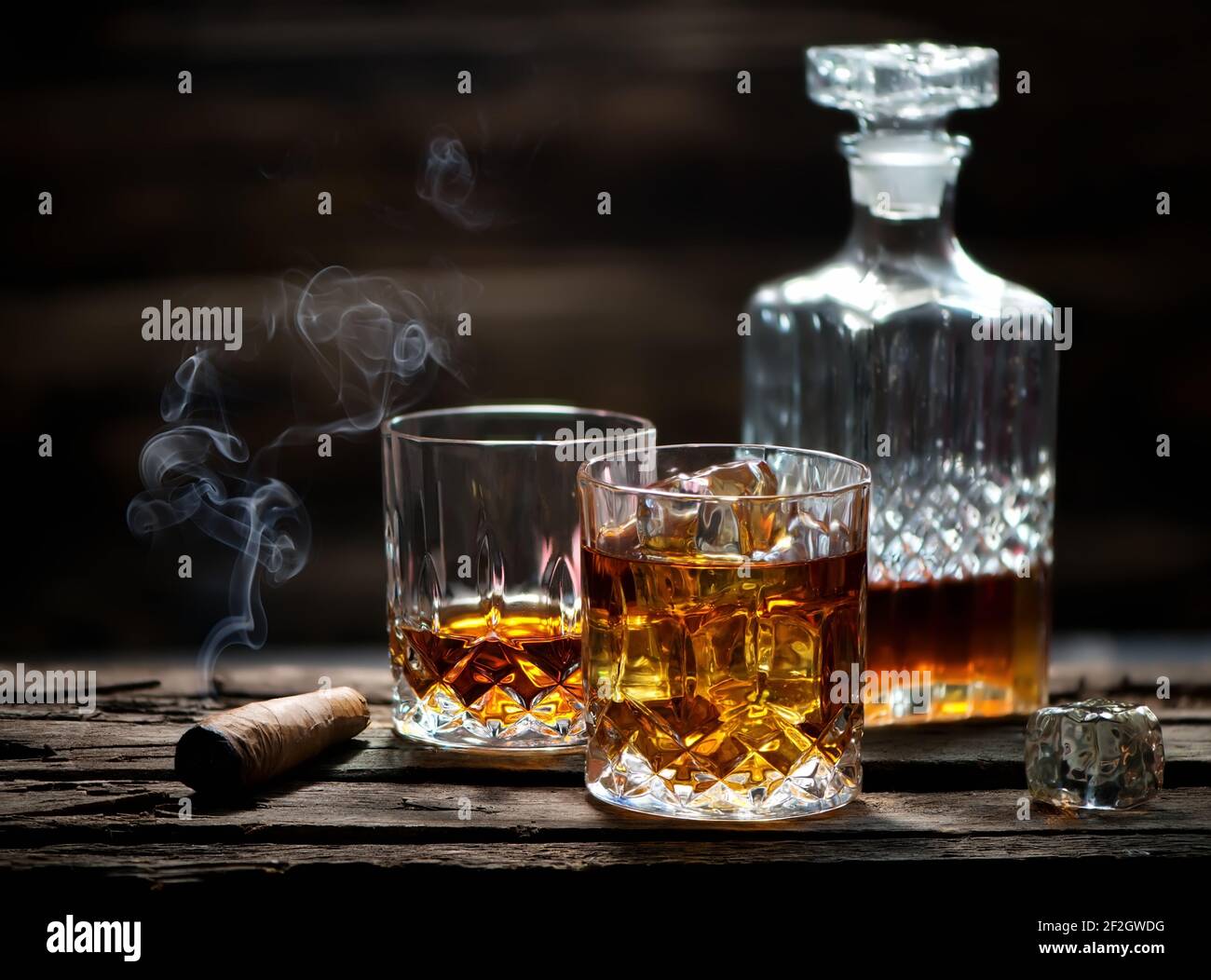 Il sigaro e vetro con il whiskey con cubetti di ghiaccio Foto Stock