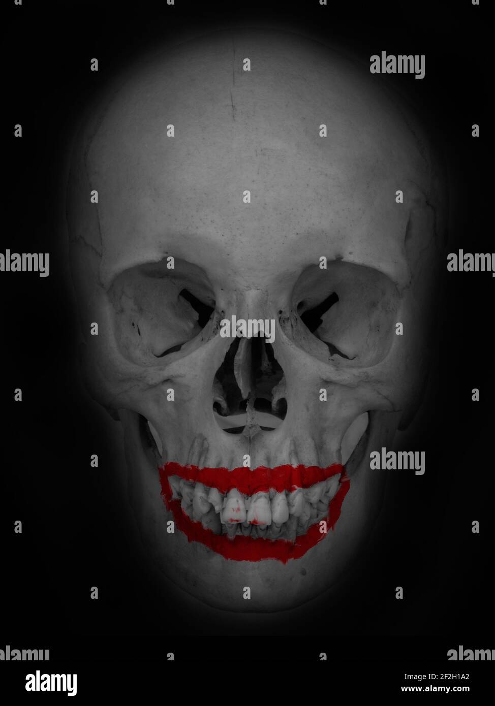 Fotomontaggio concettuale che raffigura un cranio con rossetto rosso brillante che ricorda un sorriso che sbiadisce in uno sfondo scuro. Foto Stock