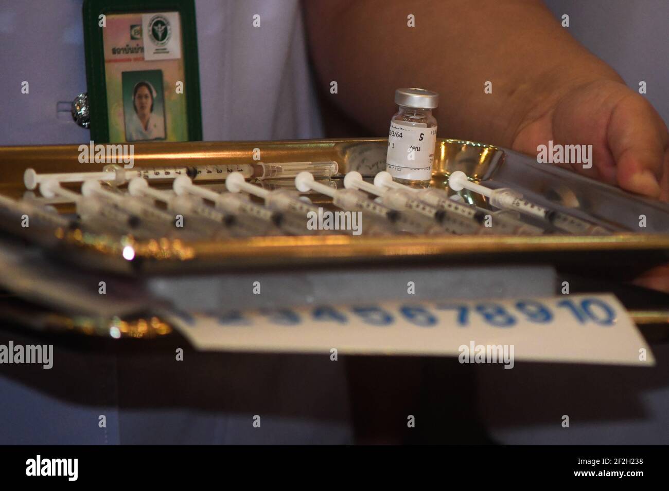 Thailandia. 12 marzo 2021. Un operatore sanitario detiene una bottiglia di vaccino AstraZeneca COVID-19 con il nome del primo ministro tailandese Prayuth Chan-ocha scritto su di esso, presso l'ospedale Bambasnaradura di Bangkok. Prayuth e i membri del suo gabinetto hanno annullato il piano di ricevere gli shot di AstraZeneca venerdì, in seguito alle relazioni sui coaguli di sangue e la sospensione in alcuni paesi europei. (Foto di Vichan Poti/Pacific Press/Sipa USA) Credit: Sipa USA/Alamy Live News Foto Stock