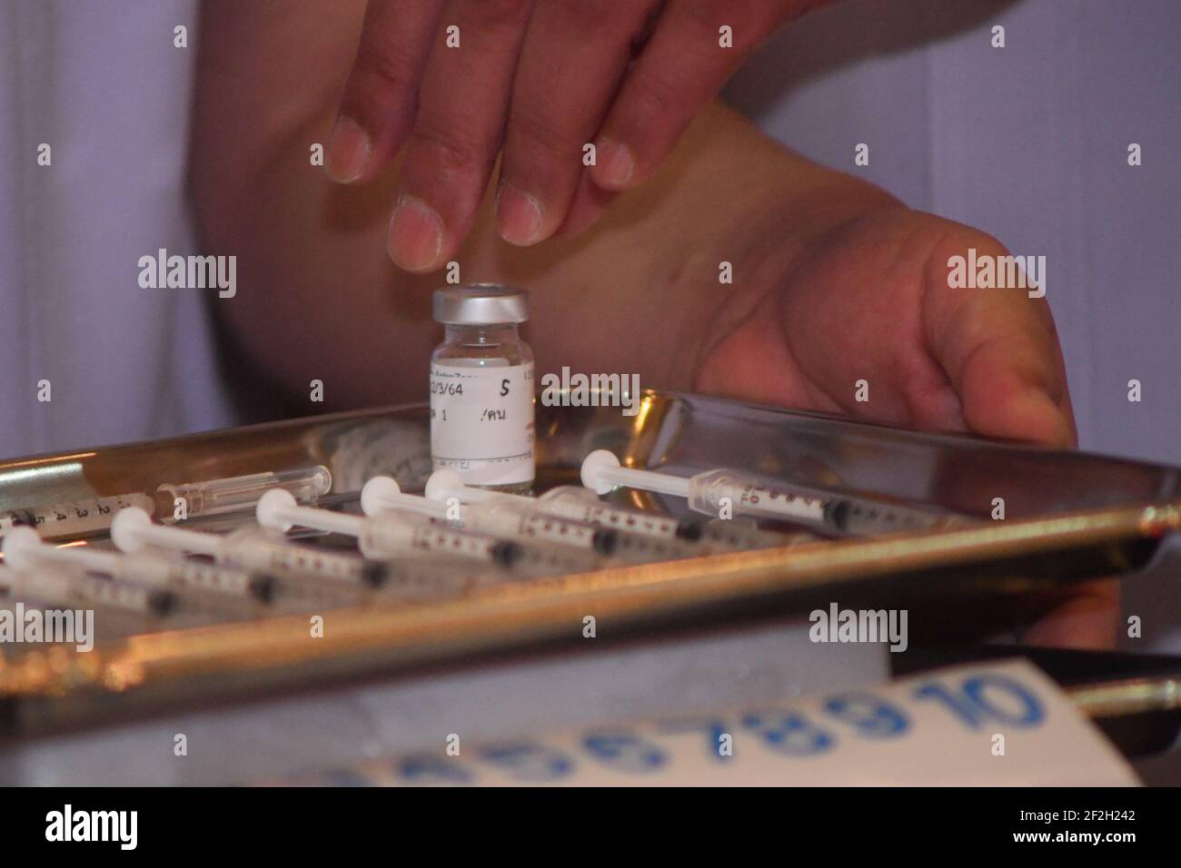 Thailandia. 12 marzo 2021. Un operatore sanitario detiene una bottiglia di vaccino AstraZeneca COVID-19 con il nome del primo ministro tailandese Prayuth Chan-ocha scritto su di esso, presso l'ospedale Bambasnaradura di Bangkok. Prayuth e i membri del suo gabinetto hanno annullato il piano di ricevere gli shot di AstraZeneca venerdì, in seguito alle relazioni sui coaguli di sangue e la sospensione in alcuni paesi europei. (Foto di Vichan Poti/Pacific Press/Sipa USA) Credit: Sipa USA/Alamy Live News Foto Stock