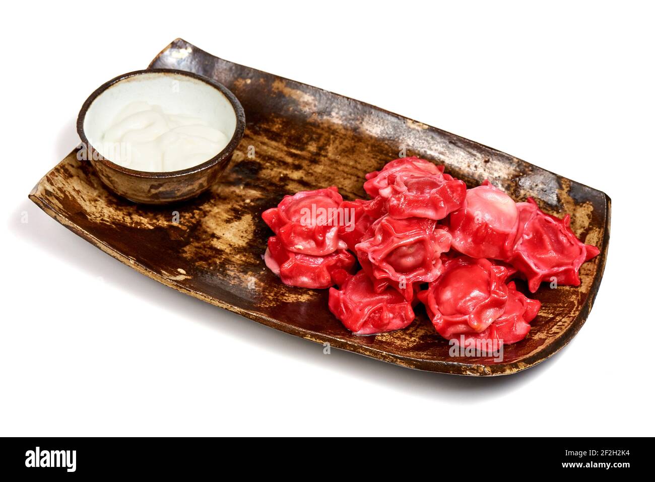 Dim sum rosso su un piatto di legno su sfondo bianco. Foto Stock