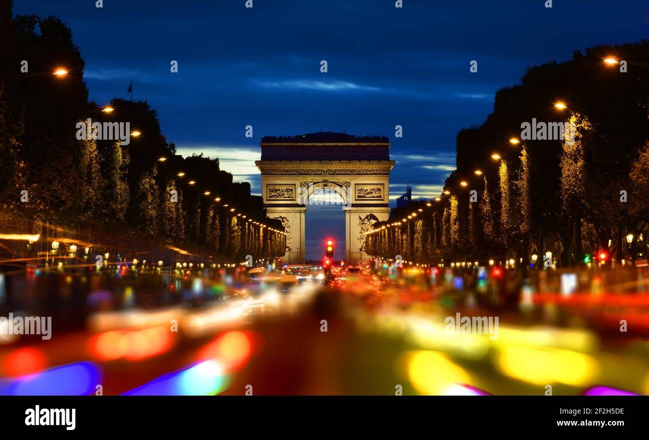 Serata di Rush Hour sugli Champs Elysee con la vista dei luminosi Arc de Triomphe a Parigi, Francia Foto Stock