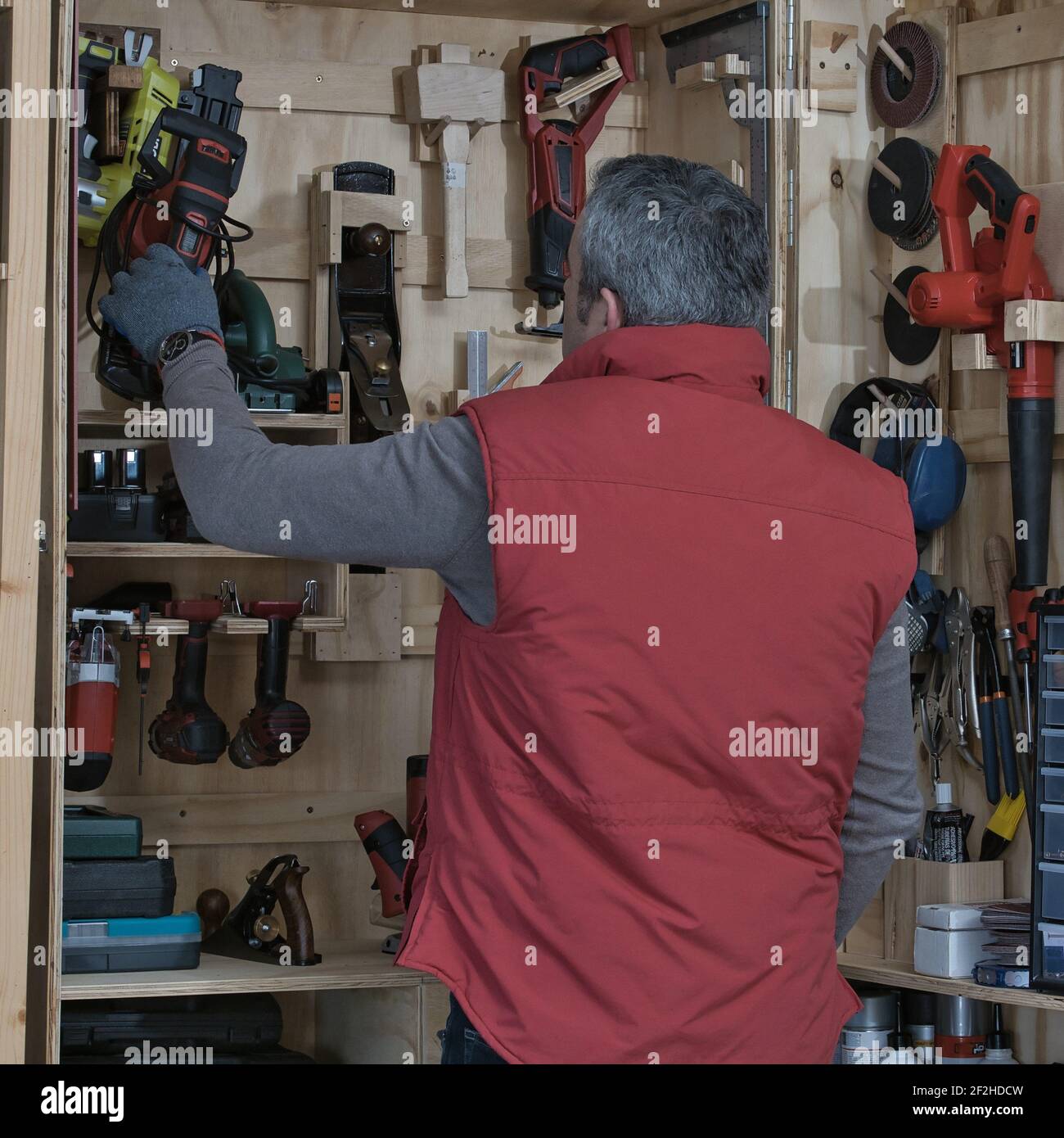 Bricolage a casa, persona che raccoglie l'attrezzo per il lavoro fai da te a casa Foto Stock