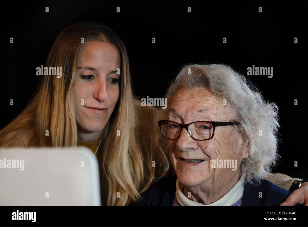 Concetto di nonna felice e nipote utilizzando il computer a home.Lifestyle ritratto di giovani generazioni che aiutano e insegnano gli anziani a. utilizzare Foto Stock