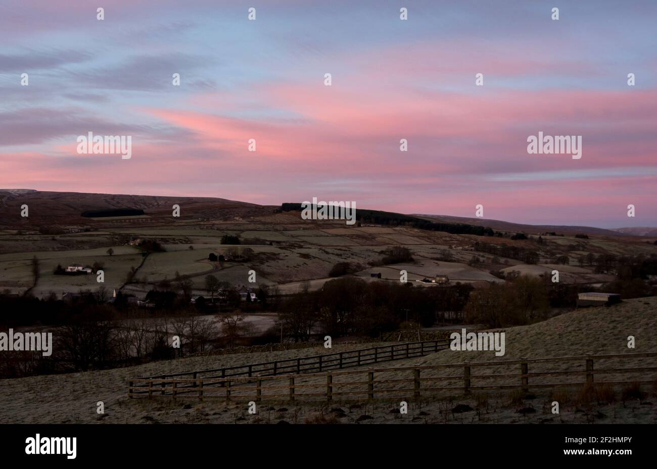 Un bacino idrico coperto nel North Pennines, Weardale, County Durham, Regno Unito, su una gelida mattina d'inverno, con un cielo rosa. Foto Stock