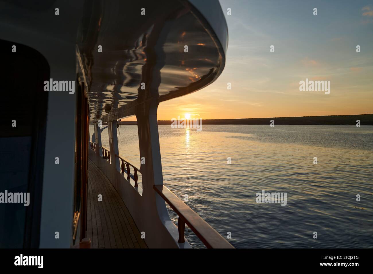 splendido e spettacolare tramonto su uno yacht a motore con riflessi sulla vernice bianca e dettagli dell'imbarcazione, sdraiato nella baia di darwin di ge Foto Stock