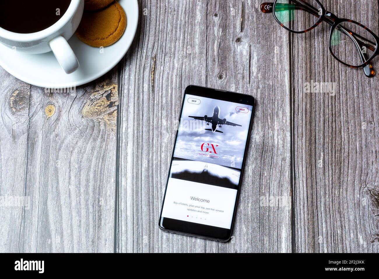 Un telefono cellulare o un telefono cellulare posato su un legno Tavolo con l'app Gatwick Express aperta sullo schermo Foto Stock